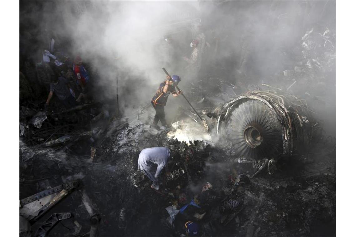 Mehr Luftfahrt-Tote trotz Rückgangs des Flugverkehrs Helfer und Einsatzkräfte suchen nach dem Absturz einer Maschine der Fluggesellschaft Pakistan International Airlines (PIA) in Karatchi nach Überlebenden. Foto: Fareed Khan/AP/dpa/Archiv