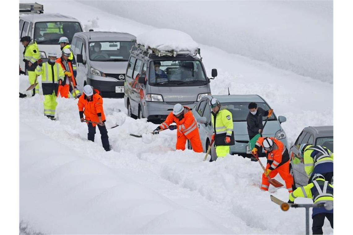 Schneechaos in Japan: Tausende im Stau und Tote Helfer versuchen, feststeckende Fahrzeuge auf einer Schnellstraße in der Präfektur Niigata freizubekommen. Foto: -/kyodo/dpa