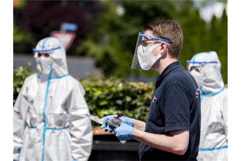 Helfer vom Deutschen Roten Kreuz im Einsatz: 40 mobile Testteams sind unterwegs, um Angestellte der Firma Tönnies zu Hause in ihrer Quarantäne aufzusuchen. Foto: David Inderlied/dpa