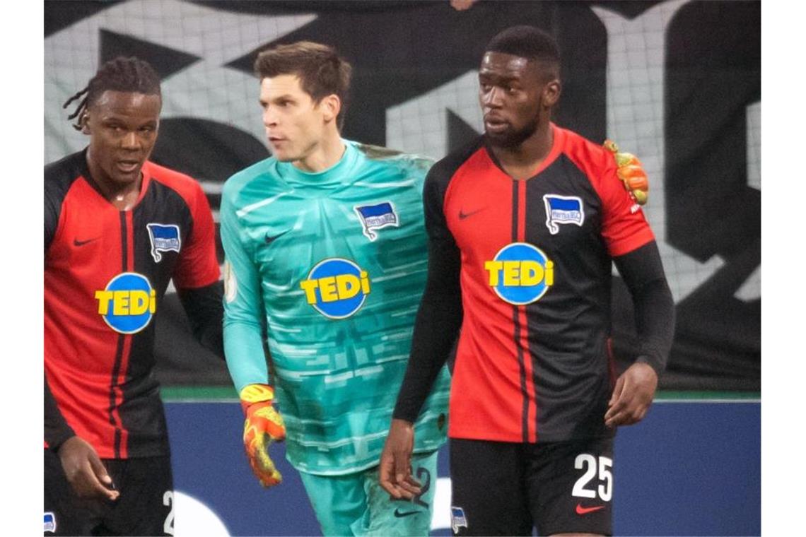 Alle für Torunarigha: Hertha-Profi einsatzbereit Herthas Dedryck Boyata (l-r) und Rune Jarstein nehmen Jordan Torunarigha vor der Schalker Nordkurve in Schutz. Foto: Bernd Thissen/dpa
