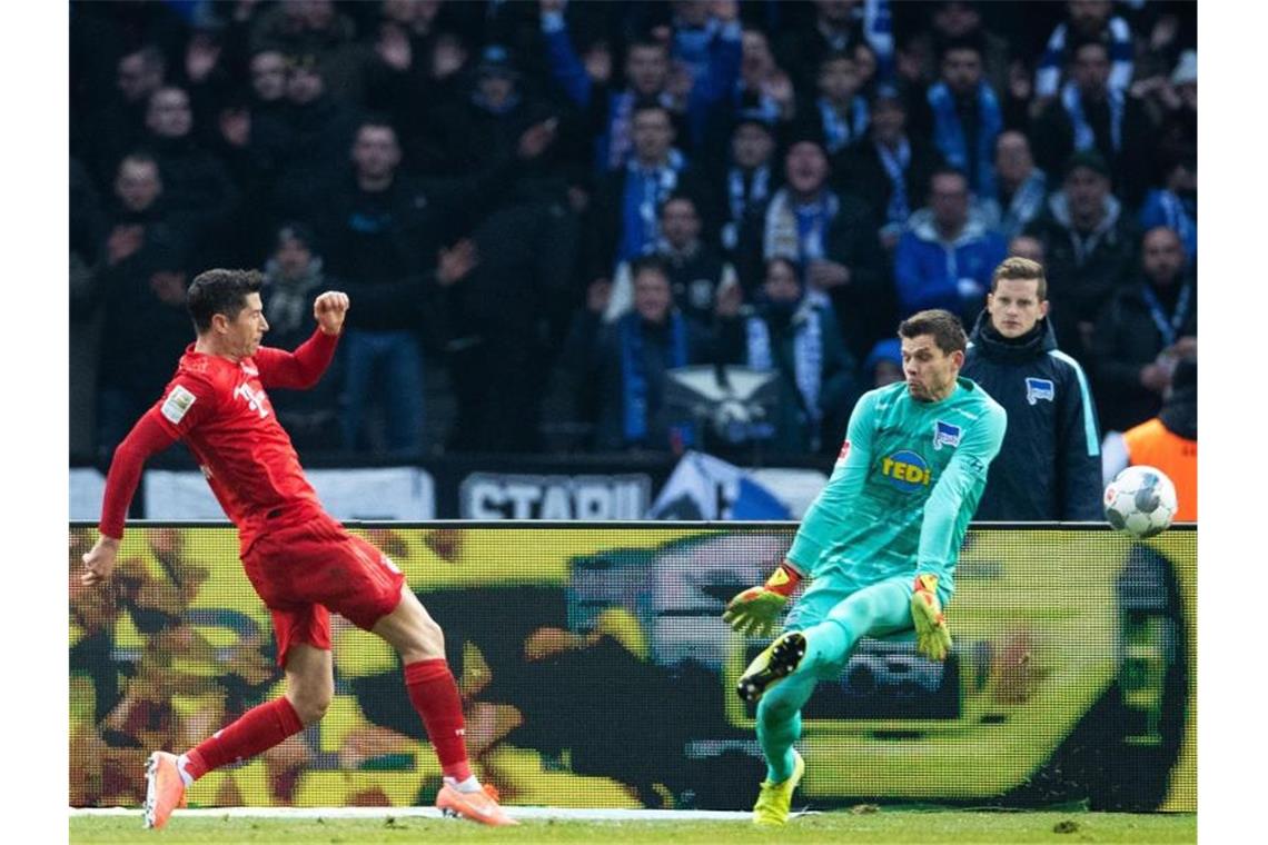 Herthas Torhüter Rune Jarstein blockt einen Schuss von Bayerns Robert Lewandowski (l) ab. Foto: Soeren Stache/dpa-Zentralbild/dpa