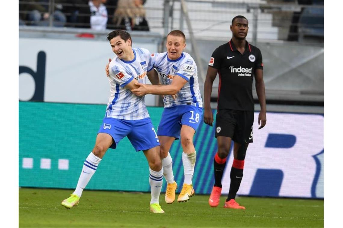 Herthas Torschütze Jürgen Ekkelenkamp (l-r) und Santiago Ascacibar jubeln nach dem Tor zum 2:0 neben Frankfurts Evan Ndicka. Foto: Arne Dedert/dpa