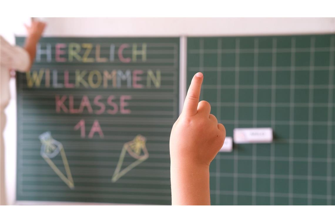 Bilder des Tages „Herzlich willkommen Klasse1 A“ steht an der Tafel eines Klassenzimmers, während sich ein Kind meldet. Am Samstag wird in Sachsen Einschulung gefeiert.