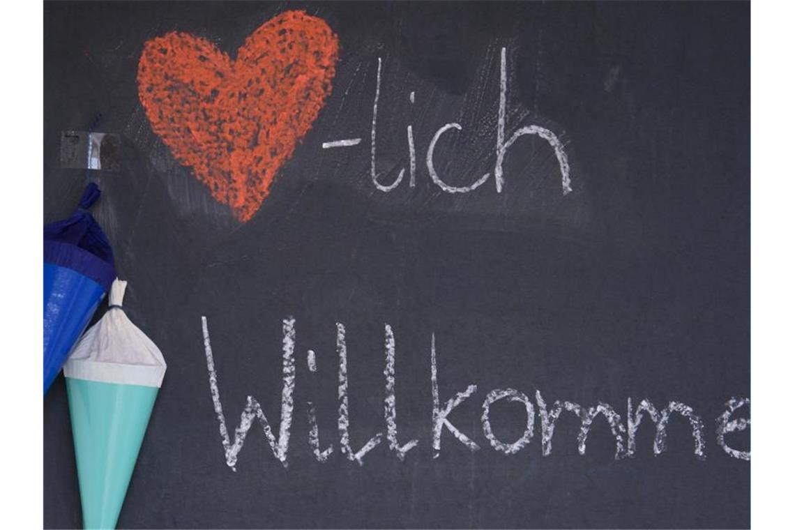 Masken und Kohorten: Neues Schuljahr begonnen "Herzlich Willkommen" steht zu Beginn des neuen Schuljahrs mit Kreide auf der Tafel eines Klassenzimmers. Foto: Robert Michael/dpa-Zentralbild/dpa/Symbol