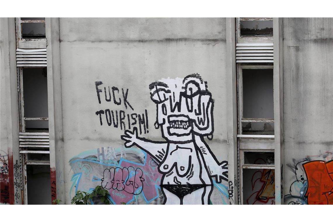 Morbider Lost Place auf windgepeitschter Urlaubsinsel Hier hat einer eine klare Meinung zum Thema Tourismus: Unzählige Graffiti überziehen die verwitterten Betonfassaden.