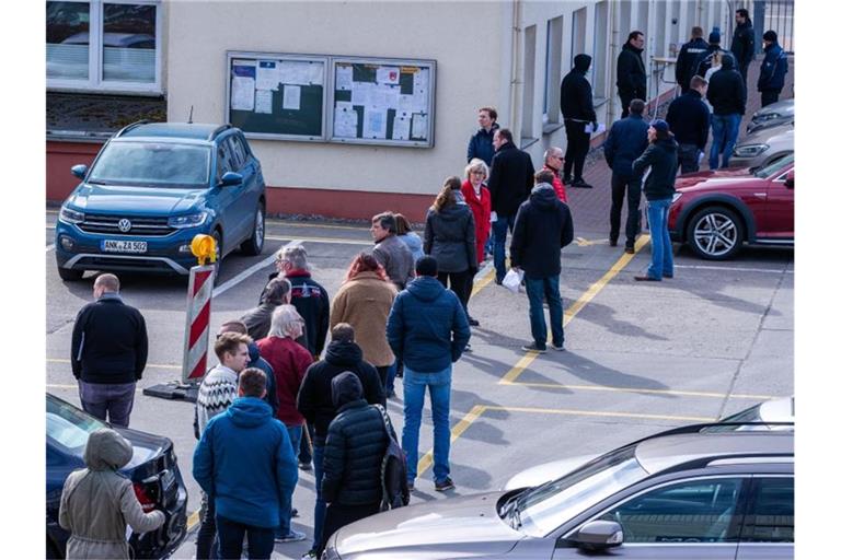 Hier ist Geduld gefragt: Apotheker und Mitarbeiter von Versorgungsbetrieben stehen auf dem Gelände des Zuckerwerks in Anklam in einer langen Schlange am Verkaufsbüro an. Foto: Jens Büttner/dpa-Zentralbild/dpa
