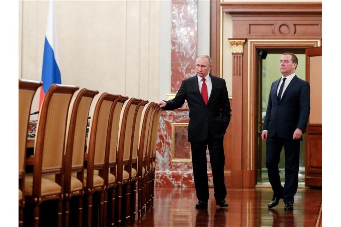 Hier sind jetzt alle Stühle freigeworden: Russlands Präsident Wladimir Putin (l) und Dmitri Medwedew vor einer Kabinettssitzung. Foto: Dmitry Astakhov/Pool Sputnik Government/AP/dpa
