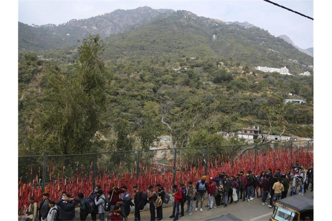 Mindestens zwölf Tote bei Massenpanik in Indien Hinduistische Gläubige stellen sich nach einer tödlichen Massenpanik in einer Reihe auf, um zur heiligen Höhle des Mata Vaishnav Devi-Schreins zu wandern. Foto: Channi Anand/AP/dpa