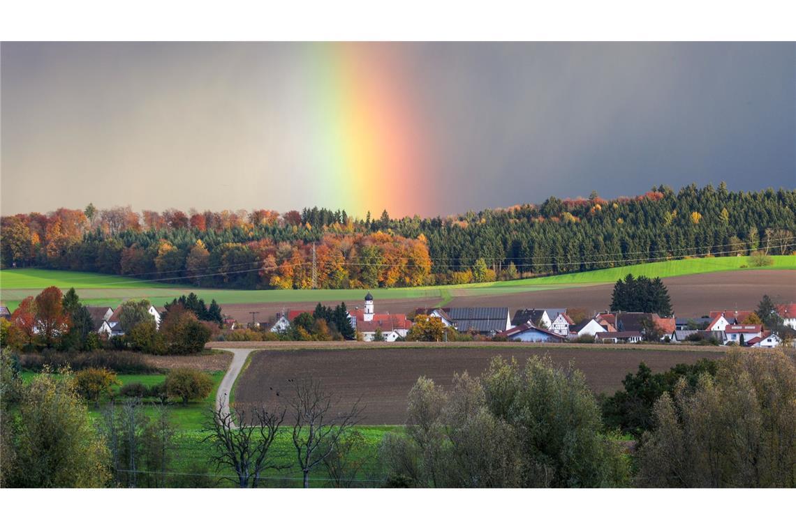 Hinter dem Dorf Dietelhofen hat sich am Morgen ein Regenbogen gebildet.
