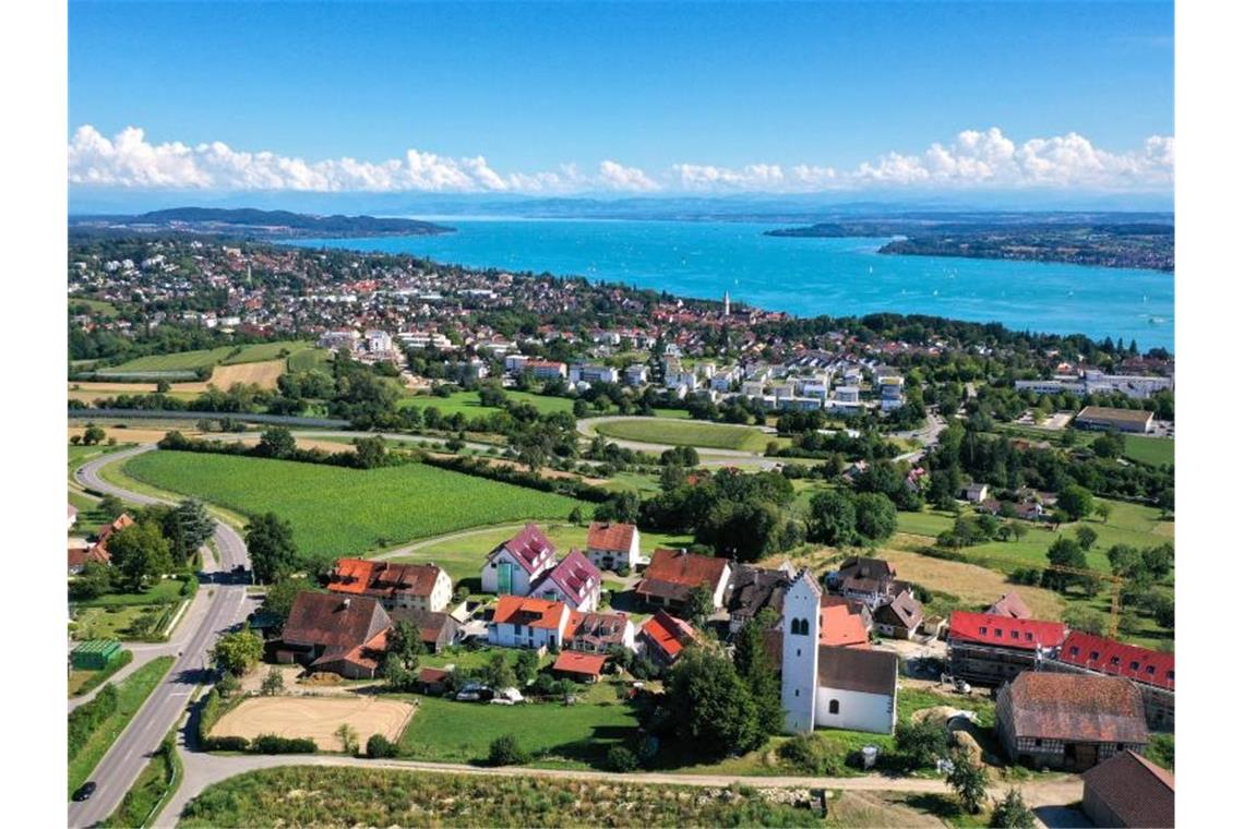 Sonnig und meist trocken im Südwesten Hinter der Kirche Sankt Michael in Aufkirch (r) liegt Überlingen am Bodensee. Foto: Felix Kästle/dpa/Archivbild