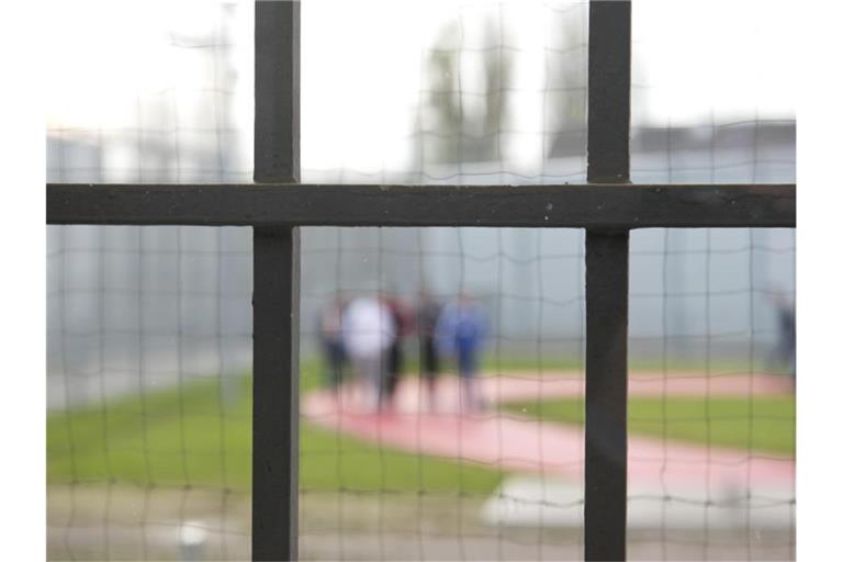 Hinter einem Gitter laufen Gefängnisinsassen der JVA Stuttgart-Stammheim über einen Gefängnishof. Foto: Daniel Naupold/dpa/Archivbild