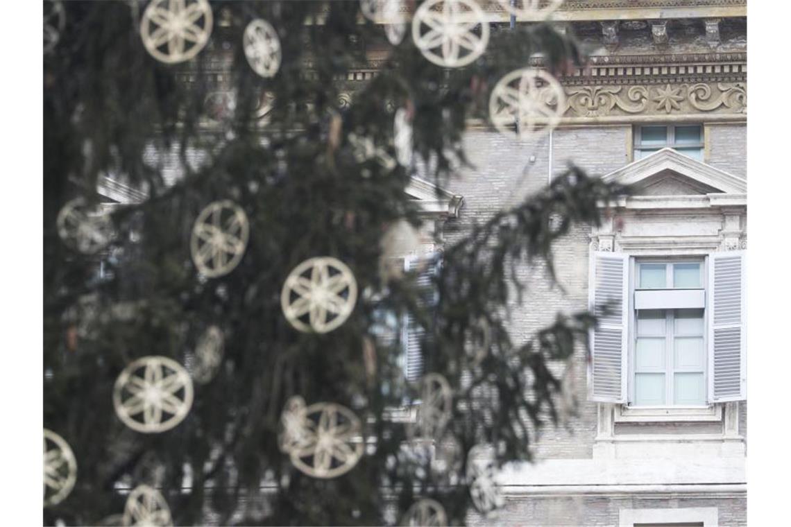 Hinter einem Weihnachtsbaum ist das Fenster des päpstlichen Ateliers geschlossen. Foto: Gregorio Borgia/AP/dpa