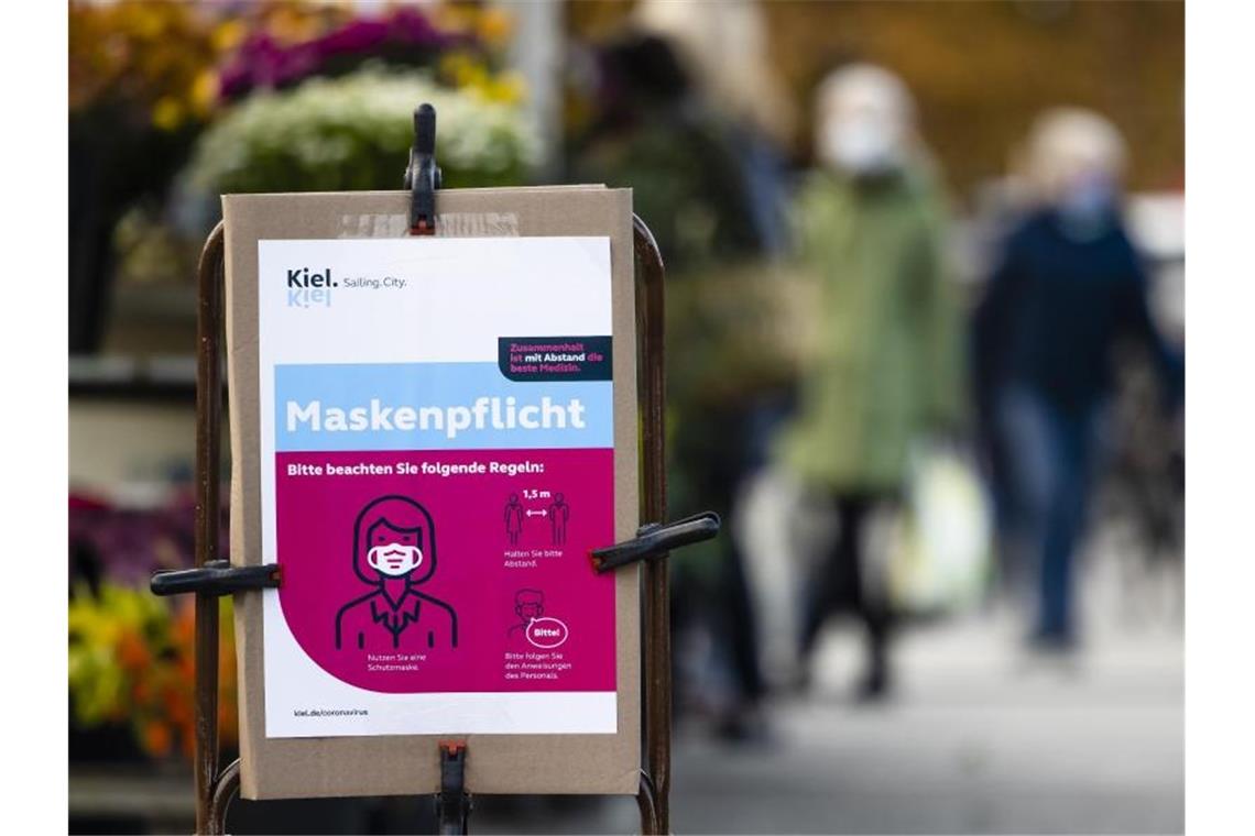 Hinweis auf die Maskenpflicht am Eingang eines Wochenmarkts in Kiel. Foto: Frank Molter/dpa