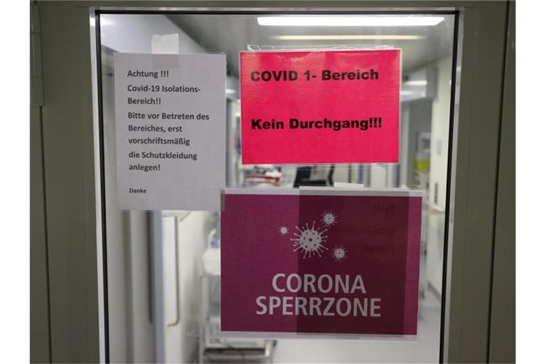 Hinweisschilder hängen am Eingang der Covid-19-Intensivstation einer Klinik in Gera. Foto: Bodo Schackow/dpa-Zentralbild/dpa