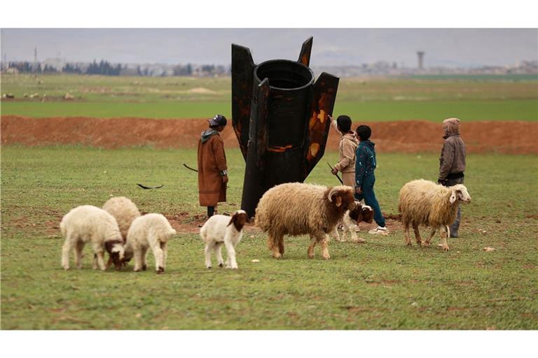 Hirtenjungen inspizieren eine nicht explodierte iranische Rakete, die auf einem offenen Feld in Qamishli in Syrien gelandet ist.