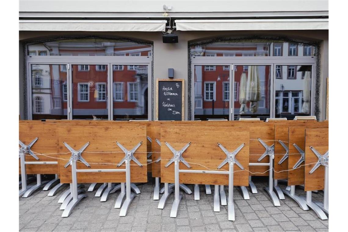 Hochgeklappte Tische stehen in der Fußgängerzone von Speyer vor einer Gastwirtschaft (Symbol). Foto: Uwe Anspach/dpa