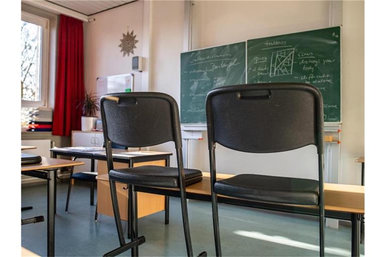 Hochgestellte Stühle in einem leeren Klassenzimmer einer Gesamtschule. Foto: Guido Kirchner/dpa