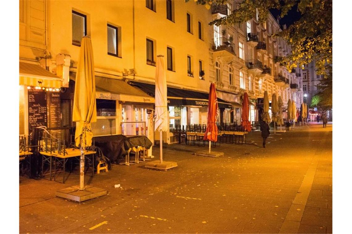 Hochgestellte Stühle und Bänke im Schanzenviertel. In Hamburg startet am Samstag ein 2-G-Modell für Geimpfte und Genesene. Foto: Daniel Bockwoldt/dpa