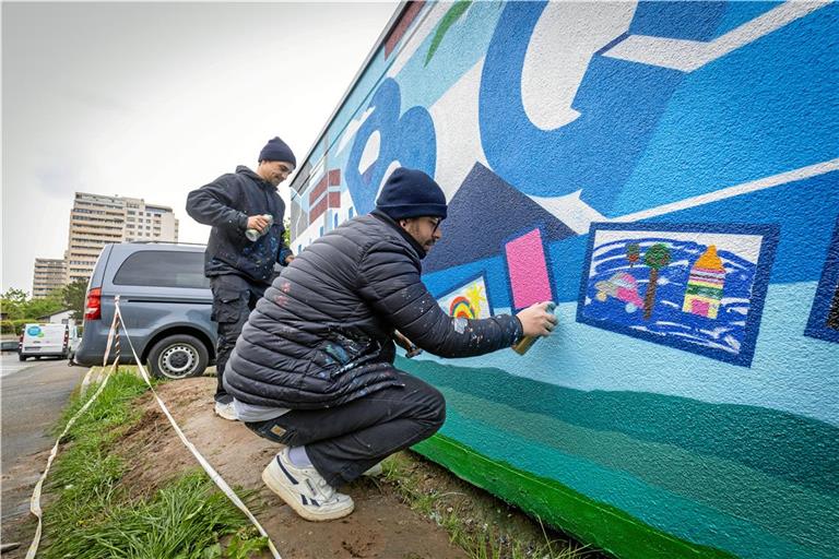 Hochkonzentriert und zugleich locker aus dem Handgelenk: Joschka Zettler (links) und Thomas Idler besprühen eine Garage in Winnenden. Das Besondere bei diesem Projekt: Sie übertragen Malereien und Zeichnungen von Kindern und bauen sie in das Gesamtkunstwerk mit ein. Foto: Alexander Becher