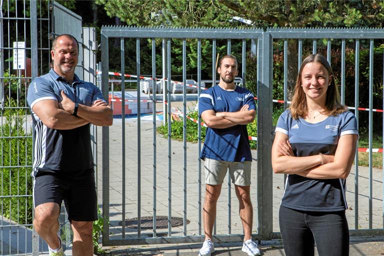 Hoffen, dass sich die Türen ins Freibad in Kürze öffnen (von links): Athletikcoach Marcel Hänsch, Wasserballer Fabio Taccogna und Schwimmerin Cara Möhle und von der TSG Backnang.Foto: A. Becher