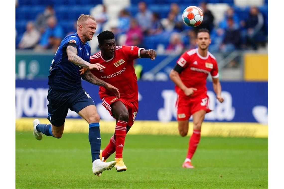 Viel Regen, kein Sieger: Hoffenheim verpasst Platz eins Hoffenheims Abwehrspieler Kevin Vogt (l) und Unions Stürmer Taiwo Awoniyi. Foto: Uwe Anspach/dpa