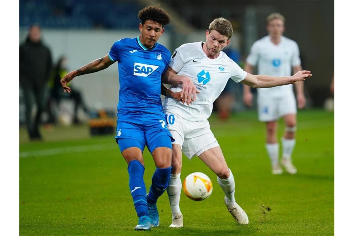 Hoffenheims Chris Richards und Moldes Björn Sigurdarsson (l-r.) im Zweikampf um den Ball. Foto: Uwe Anspach/dpa Pool/dpa