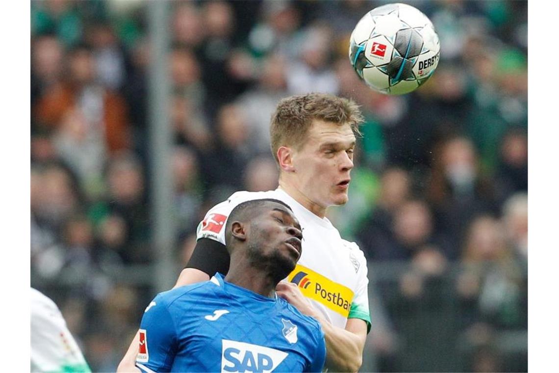 Hoffenheims Diadie Samassekou und Mönchengladbachs Matthias Ginter (l-r.) im Zweikampf um den Ball. Foto: Roland Weihrauch/dpa