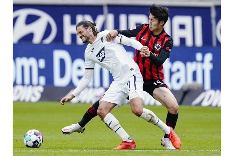 Hoffenheims Florian Grillitsch und Frankfurts Daichi Kamada (l-r.) im Duell um den Ball. Foto: Uwe Anspach/dpa