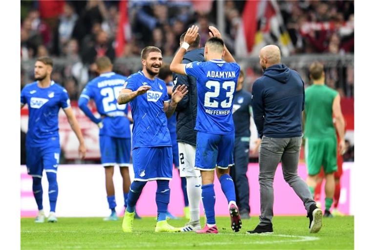 Hoffenheims Konstantinos Stafylidis (l) gratuliert Doppeltorschütze Sargis Adamyan zur Leistung gegen die Bayern. Foto: Tobias Hase/dpa