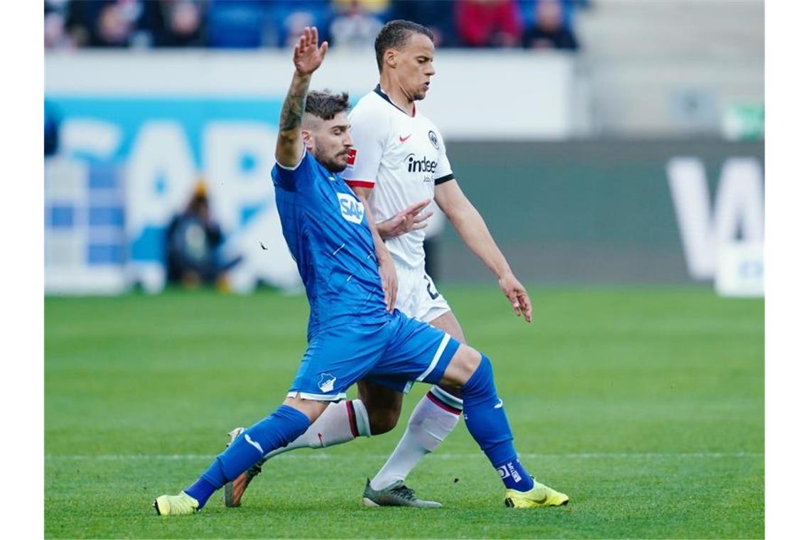 Hoffenheims Konstantinos Stafylidis und Frankfurts Timothy Chandler (l-r.) im Zweikampf um den Ball. Foto: Uwe Anspach/dpa