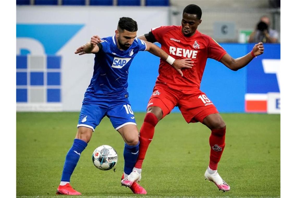 Hoffenheims Munas Dabbur und Kingsley Ehizibue aus Köln (l-r.) in Aktion. Foto: Ronald Wittek/epa-Pool/dpa