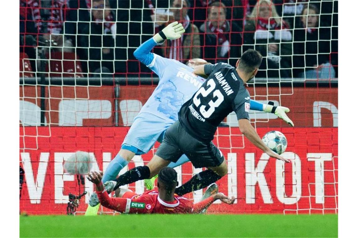 Hoffenheims Sargis Adamyan (r.) trifft gegen Kölns Torwart Timo Horn und Kingsley Ehizibue. Foto: Rolf Vennenbernd/dpa