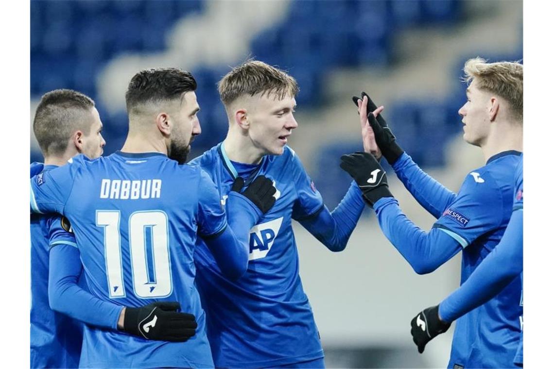 Hoffenheims Torschütze Maximilian Beier (M) jubelt mit seinen Mannschaftskollegen über das Tor zum 3:0. Foto: Uwe Anspach/dpa