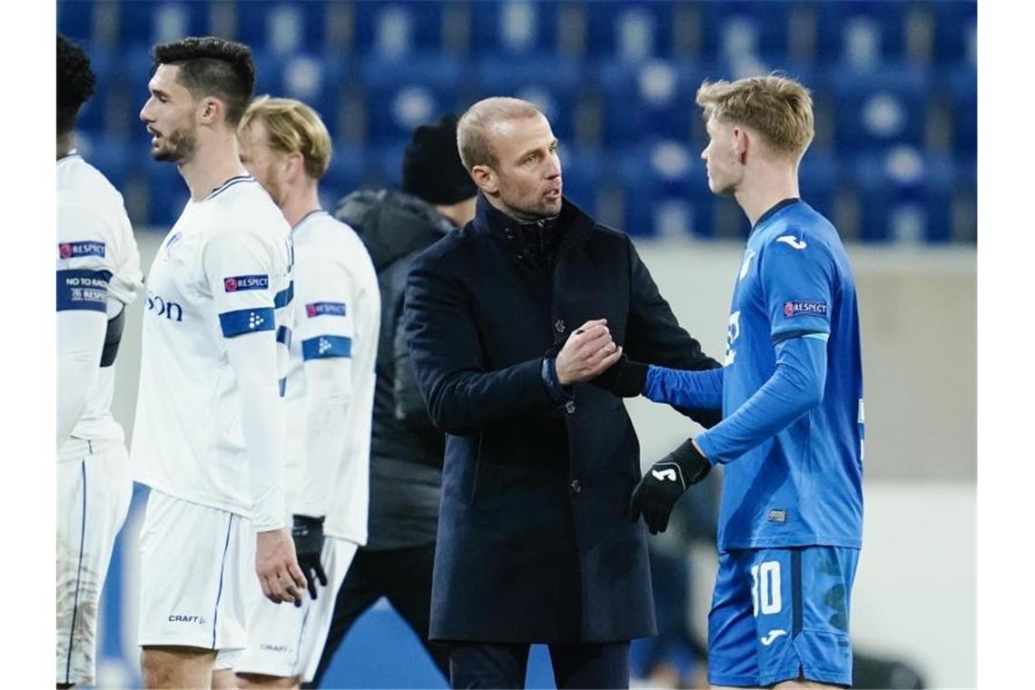 Hoffenheims Trainer Sebastian Hoeneß (2.v.r.) bedankt sich nach Spielende bei Hoffenheims Marco John (r). Foto: Uwe Anspach/dpa/Archivbild