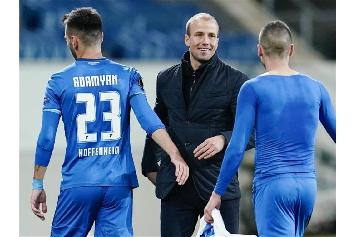 Hoffenheims Trainer Sebastian Hoeneß (M) freut sich nach Spielende mit Sargis Adamyan (l) und Mijat Gacinovic über den Sieg. Foto: Uwe Anspach/dpa