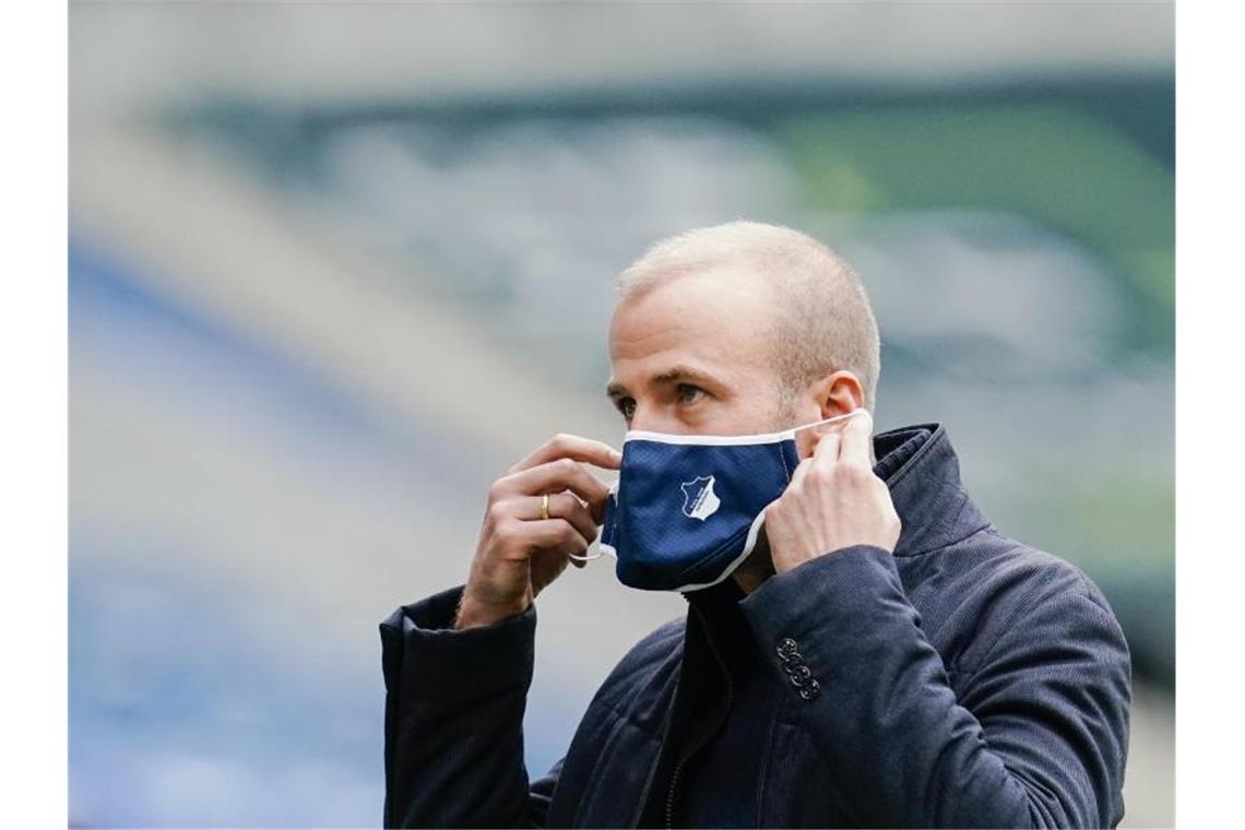 Hoffenheims Trainer Sebastian Hoeneß zieht seinen Mund-Nasenschutz auf. Foto: Uwe Anspach/dpa/Archivbild