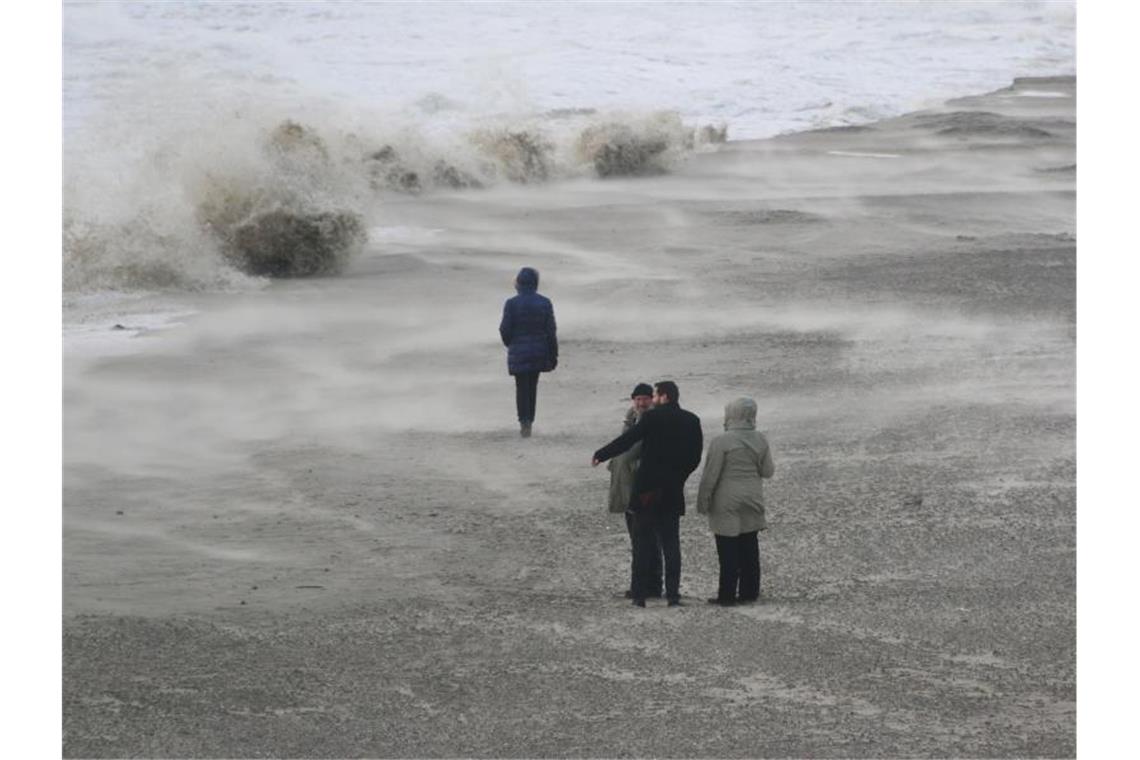 Hohe Wellen schlagen an den Strand von Wangerooge und nehmen den Sand mit. Foto: Peter Kuchenbuch-Hanken/dpa