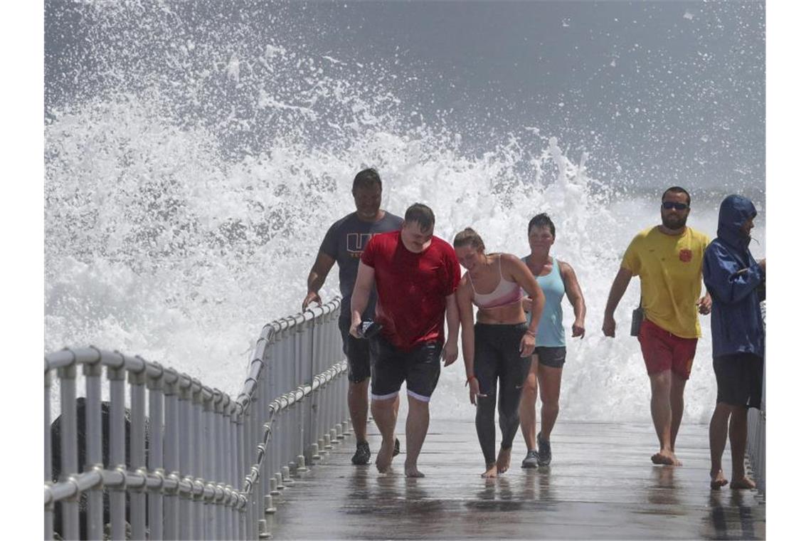 Hoher Wellengang: In Port Orange in Florida verlassen Menschen einen Steg. Foto: Joe Burbank/Orlando Sentinel/AP