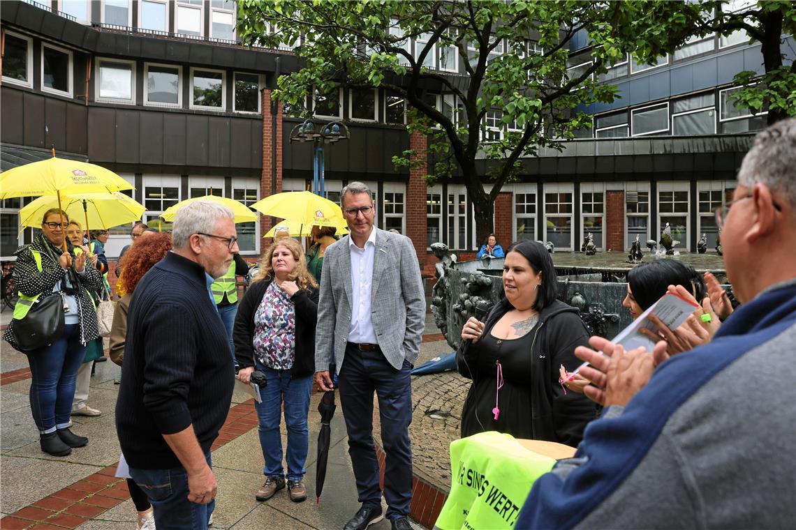 Holger Gläss (links) und Richard Sigel (Mitte) im Gespräch mit Demonstrantinnen vor dem Landratsamt in Waiblingen.Foto: Benjamin Büttner