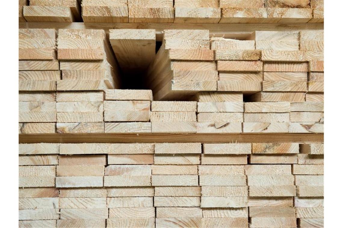 Holzbretter liegen aufeinandergestapelt in einem Palettenwerk. Foto: picture alliance/dpa/Symbolbild