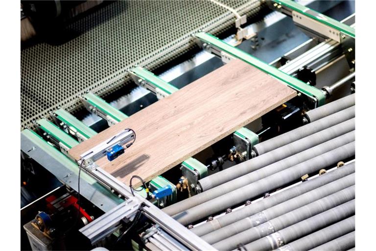 Holzplatten für Schreibtische werden in der Produktion von fm Büromöbel GmbH automatisch zugeschnitten. Die durch die Corona-Pandemie veränderten Arbeitswelten wirken sich auch auf das Geschäft der Hersteller von Büromöbeln aus, die Branche ist im Umbruch. Foto: Hauke-Christian Dittrich/dpa