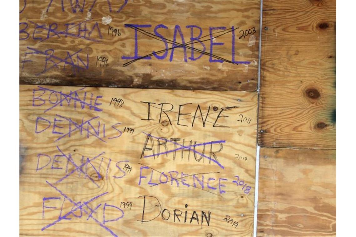 Holzplatten vor Ladenfenstern im Ort New Bern sind mit Namen von Hurrikans beschriftet, die seit 1996 den Ort getroffen haben. Foto: Gray Whitley/Sun Journal/AP