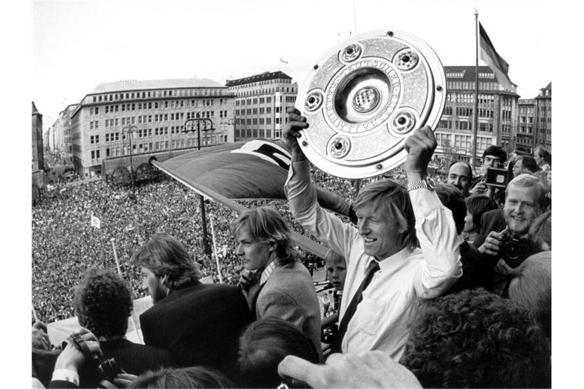 Kopfball-Ungeheuer, Menschenfänger, Angler: Hrubesch wird 70 Horst Hrubesch (M) zeigt auf dem Balkon des Hamburger Rathauses die eroberte Meisterschale. Foto: Werner Baum/dpa