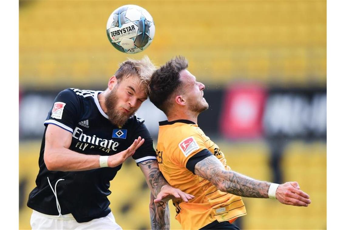 Hamburger SV mit spätem Sieg bei Schlusslicht Dynamo Dresden HSV-Profi Timo Letschert (l) im Kopfballduell mit Patrick Schmidt. Foto: Robert Michael/dpa-Pool/dpa