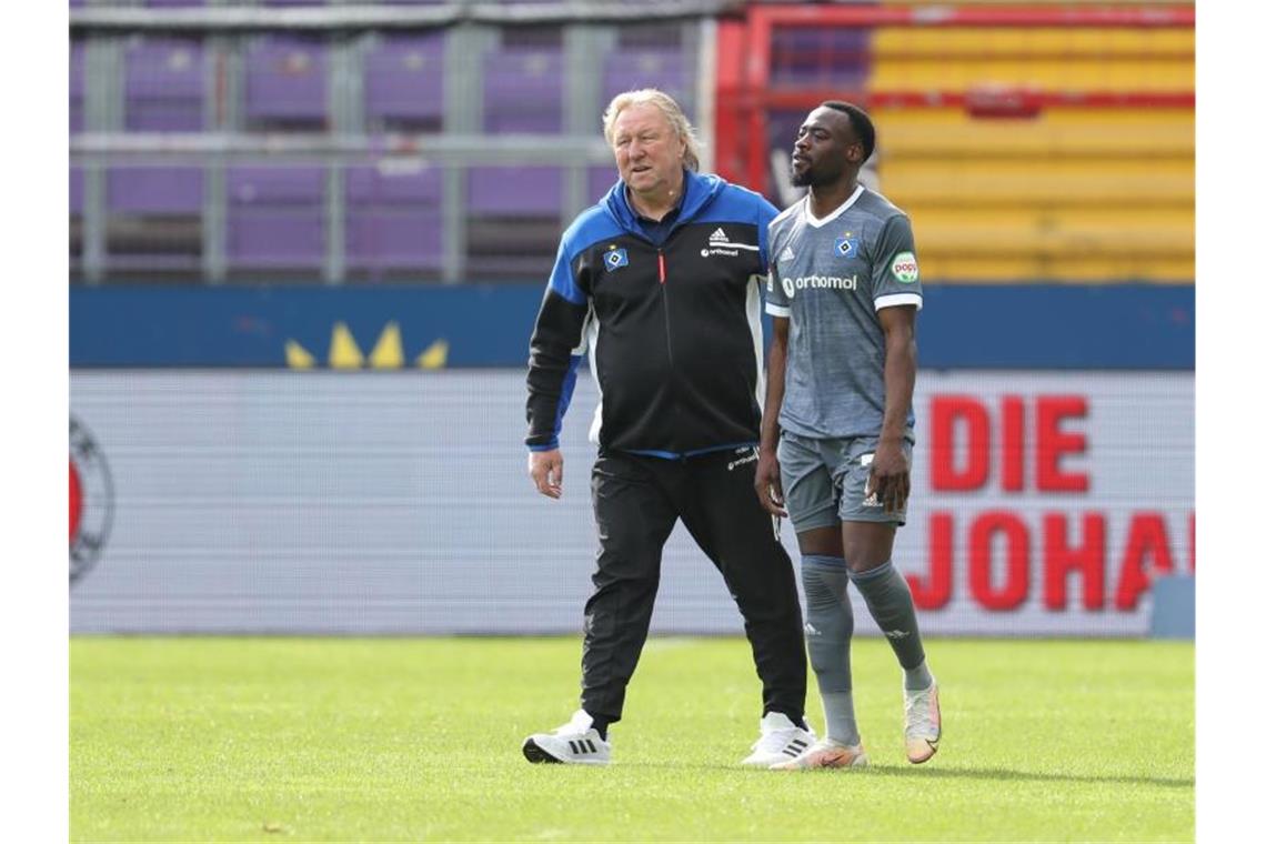 HSV-Trainer Horst Hrubesch (l) tröstet Khaled Narey nach Spielende. Die Hamburger haben den Aufstieg erneut verpasst. Foto: Friso Gentsch/dpa