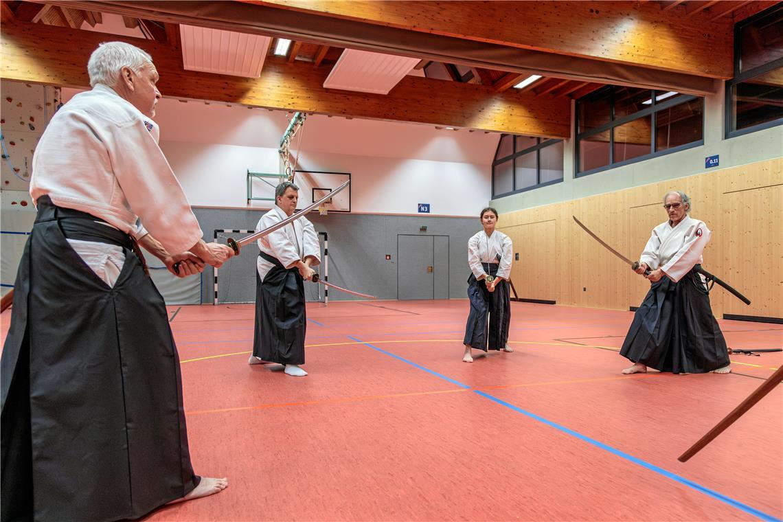 Hubert Wiedemann (von links), sein Sohn Alexander, Lina Widmann und Trainer Gerald Bauer trainieren einmal in der Woche den Kampf mit dem Katana, dem Schwert der Samurai, in der Sporthalle der Bodelschwinghschule in Murrhardt. Foto: Stefan Bossow