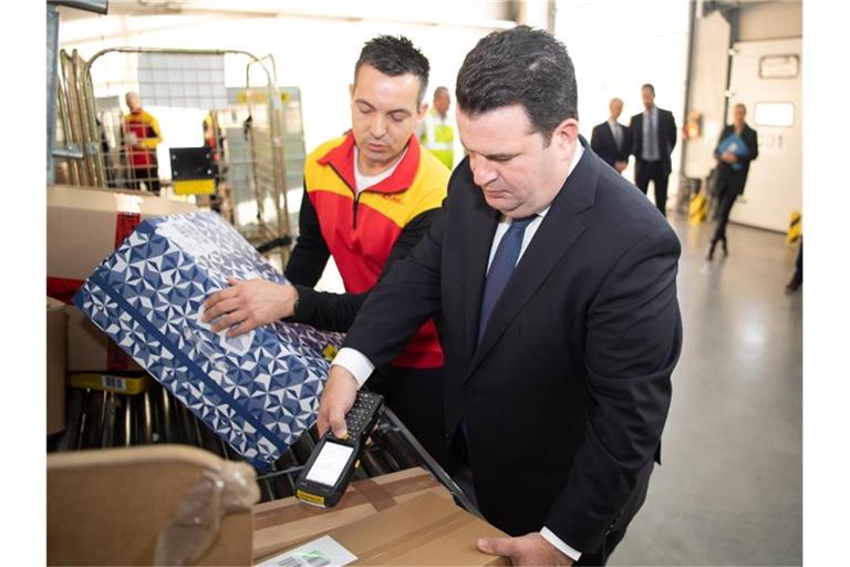 Hubertus Heil (SPD, r), Bundesarbeitsminister, besucht eine Zustellbasis der Deutschen Post (DHL) in Berlin Marzahn. Foto: Tom Weller