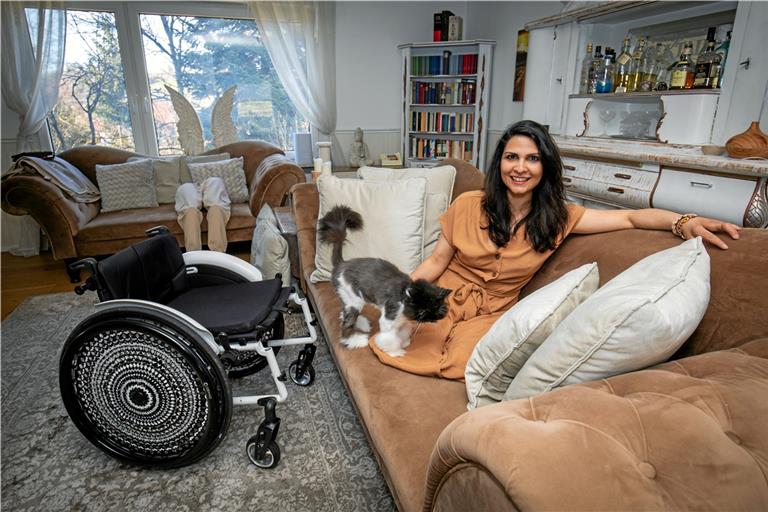 Hülya Marquardt sitzt mit Katze Feline auf der Couch in ihrem Wohnzimmer. Auf dem Sofa im Hintergrund haben ihre Prothesen Platz genommen. Fotos: A. Becher