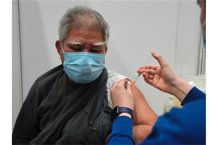 Hui Ngai-seng erhält in einem Impfzentrum in Hongkong seine erste Dosis des chinesischen Corona-Impfstoffs Sinovac. Foto: Kin Cheung/AP/dpa