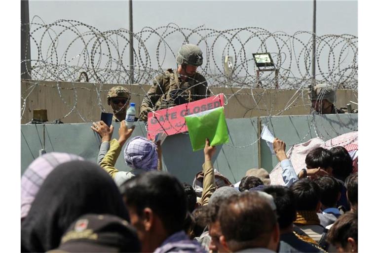 Hunderte Menschen hoffen vor einem Evakuierungskontrollpunkt auf dem Gelände des Flughafens von Kabul darauf, außer Landes zu gelangen. Foto: Wali Sabawoon/AP/dpa